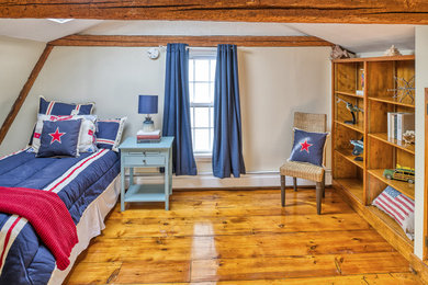 Example of a mid-sized classic boy medium tone wood floor and brown floor kids' room design in Boston with beige walls