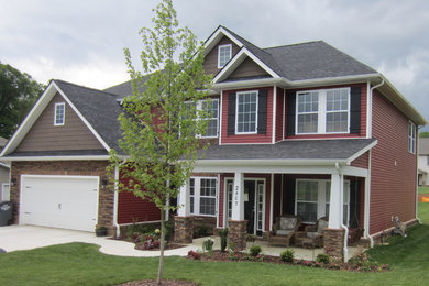 Large elegant red two-story wood gable roof photo in Other