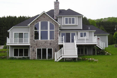 Inspiration for a large contemporary gray three-story concrete fiberboard exterior home remodel in Other with a hip roof