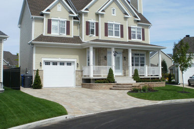 Example of a beige three-story stone gable roof design in Montreal
