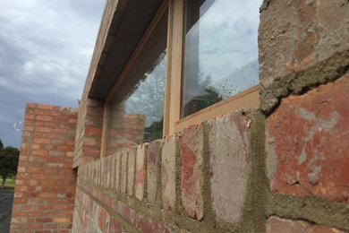 This is an example of a modern brick exterior in Melbourne with a flat roof and a metal roof.