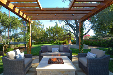 Inspiration for a transitional backyard concrete paver patio remodel in San Francisco with a fire pit and a pergola