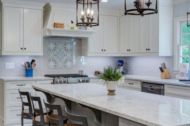 Inspiration for a mid-sized transitional l-shaped medium tone wood floor and brown floor open concept kitchen remodel in Atlanta with an undermount sink, shaker cabinets, white cabinets, quartz countertops, gray backsplash, subway tile backsplash, stainless steel appliances, an island and multicolored countertops