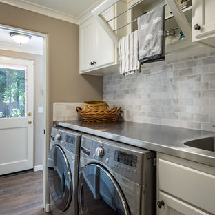 Photo of a small contemporary galley separated utility room in Other with an utility sink, shaker cabinets, white cabinets, grey walls, dark hardwood flooring, a side by side washer and dryer, brown floors, white worktops and stainless steel worktops.