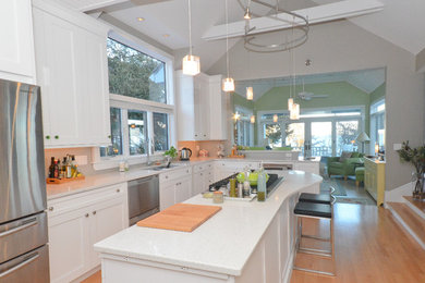 Open concept kitchen - large transitional light wood floor open concept kitchen idea in Jacksonville with an undermount sink, recessed-panel cabinets, white cabinets, terrazzo countertops, stainless steel appliances, an island and white countertops