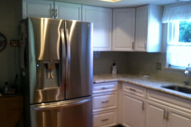 Enclosed kitchen - small traditional u-shaped medium tone wood floor enclosed kitchen idea in Detroit with an undermount sink, raised-panel cabinets, white cabinets, granite countertops, white backsplash, subway tile backsplash, stainless steel appliances and no island