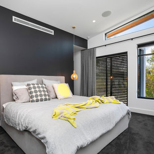 Réalisation d'une grande chambre design avec un mur noir et un sol noir.