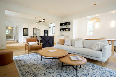 Ejemplo de salón abierto y blanco y madera contemporáneo grande con paredes blancas, suelo de madera en tonos medios, televisor colgado en la pared y suelo beige