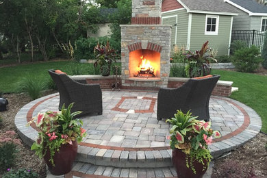 This is an example of a mid-sized country backyard patio in Minneapolis with with fireplace and concrete pavers.