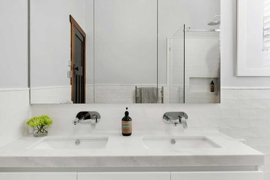 Photo of a mid-sized contemporary bathroom in Newcastle - Maitland with white cabinets, white walls and white benchtops.