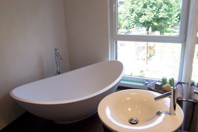 Imagen de cuarto de baño principal, único y de pie clásico grande con puertas de armario de madera en tonos medios, bañera exenta y lavabo tipo consola