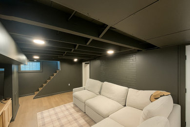 Example of a large vinyl floor, beige floor and exposed beam basement design in Cleveland