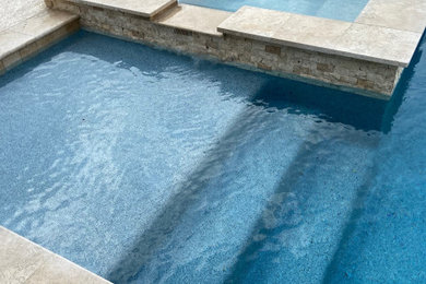 Design ideas for a rectangular swimming pool in Houston with concrete slabs.