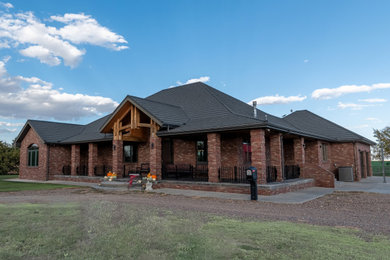 Large elegant red one-story brick exterior home photo in Denver with a metal roof and a gray roof