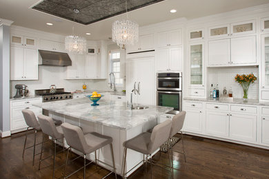 Large transitional l-shaped dark wood floor open concept kitchen photo in DC Metro with a farmhouse sink, recessed-panel cabinets, white cabinets, quartzite countertops, white backsplash, ceramic backsplash, stainless steel appliances and an island
