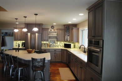 Inspiration for a timeless l-shaped kitchen remodel in Other with an integrated sink, raised-panel cabinets, gray cabinets, solid surface countertops, mosaic tile backsplash, an island and white countertops