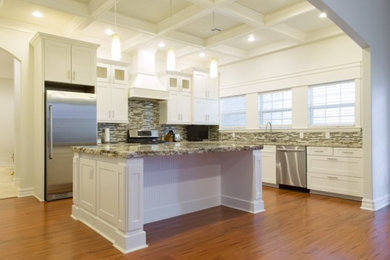 Example of a large transitional l-shaped open concept kitchen design in Oklahoma City with shaker cabinets, white cabinets, granite countertops, multicolored backsplash, stainless steel appliances and an island