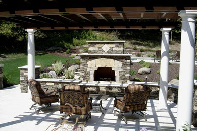 Inspiration for a mid-sized transitional backyard concrete patio remodel in New York with a fire pit and a pergola
