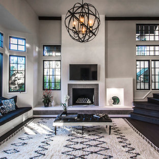 Mediterranes Wohnzimmer mit grauer Wandfarbe, dunklem Holzboden, Kamin, Wand-TV und gefliestem Kaminsims in Santa Barbara