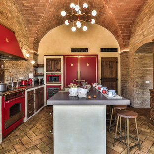 Immagine di un'ampia cucina mediterranea chiusa con lavello stile country, ante di vetro, ante in legno scuro, top in quarzite, paraspruzzi multicolore, paraspruzzi in quarzo composito, elettrodomestici da incasso, pavimento in terracotta, pavimento arancione, top multicolore e soffitto a volta