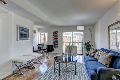 Example of a small beach style open concept light wood floor and beige floor family room design in DC Metro with white walls
