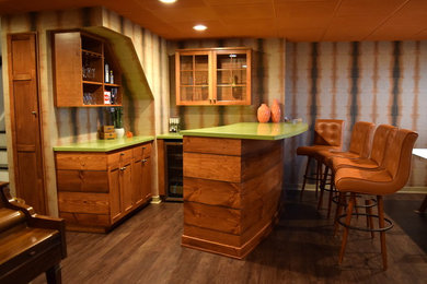 Example of a mid-sized minimalist dark wood floor seated home bar design in New York with recessed-panel cabinets, medium tone wood cabinets and solid surface countertops