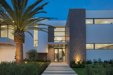 Photo of an expansive modern two-storey white house exterior in Miami with a flat roof.
