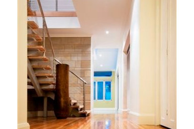 Photo of a contemporary hallway in Adelaide with light hardwood floors and white walls.