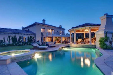 Large tuscan beige two-story vinyl gable roof photo in Los Angeles