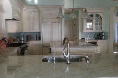 Example of a large beach style u-shaped open concept kitchen design in Miami with an undermount sink, raised-panel cabinets, beige cabinets, marble countertops, blue backsplash, mosaic tile backsplash, paneled appliances and an island