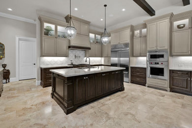 Example of a large transitional l-shaped travertine floor, beige floor and exposed beam eat-in kitchen design in Houston with an undermount sink, raised-panel cabinets, beige cabinets, quartzite countertops, white backsplash, marble backsplash, stainless steel appliances, an island and beige countertops