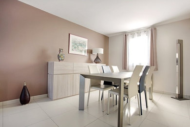 This is an example of a large transitional dining room in Paris with beige walls, porcelain floors and no fireplace.