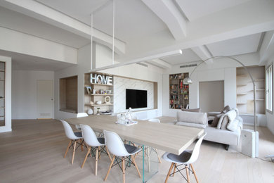 Example of a large danish loft-style medium tone wood floor, brown floor, tray ceiling and wall paneling family room library design in Milan with white walls and a media wall