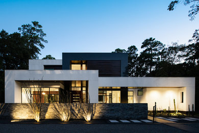Example of a large trendy white two-story stucco exterior home design