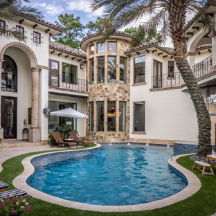 Immagine di un'ampia piscina naturale mediterranea personalizzata in cortile con una vasca idromassaggio