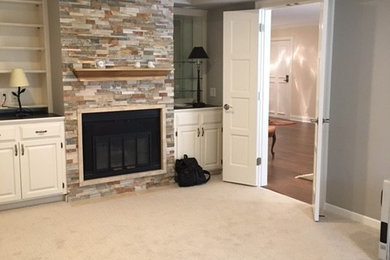 Example of a mid-sized trendy carpeted study room design in Minneapolis with beige walls, a standard fireplace and a stone fireplace