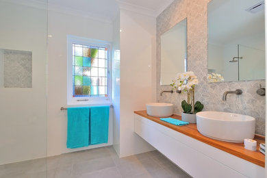 Inspiration for a mid-sized traditional master wet room bathroom in Perth with flat-panel cabinets, white cabinets, gray tile, marble, white walls, porcelain floors, a vessel sink, wood benchtops, grey floor and an open shower.