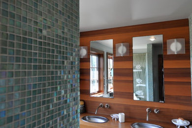 Example of a large trendy master blue tile and mosaic tile dark wood floor and brown floor alcove shower design in Boston with flat-panel cabinets, dark wood cabinets, brown walls, a drop-in sink, wood countertops and a hinged shower door