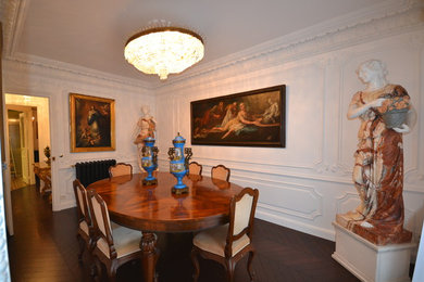 This is an example of a transitional dining room in Paris with white walls, medium hardwood floors and brown floor.