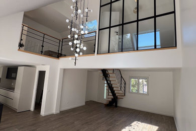 Aménagement d'une salle à manger moderne avec un mur blanc, un sol en bois brun, un sol marron et verrière.