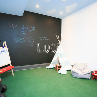 トロントの大きいモダンスタイルのおしゃれな地下室 (半地下 (窓あり) 、グレーの壁、濃色無垢フローリング、標準型暖炉、緑の床) の写真