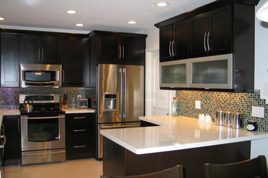 Example of a mid-sized transitional u-shaped porcelain tile eat-in kitchen design in Miami with an undermount sink, shaker cabinets, dark wood cabinets, quartz countertops, green backsplash, glass tile backsplash, stainless steel appliances and a peninsula