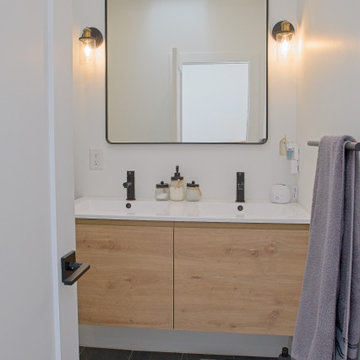 Floating Wood Double Vanity with Black Faucets and Wall Sconces | East York