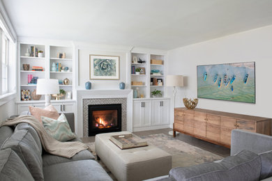 Example of a medium tone wood floor living room design in Philadelphia with white walls, a standard fireplace, a tile fireplace and a wall-mounted tv