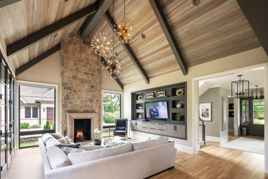 Inspiration for a country open concept family room in Chicago with beige walls, light hardwood floors, a standard fireplace, a stone fireplace surround, a built-in media wall and beige floor.