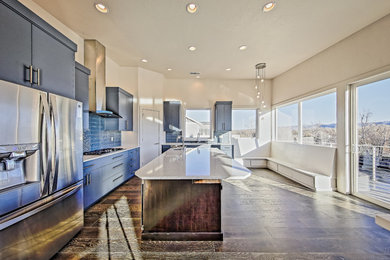 Inspiration for a large modern l-shaped dark wood floor eat-in kitchen remodel in Boise with flat-panel cabinets, blue cabinets, stainless steel appliances, two islands, quartz countertops and blue backsplash