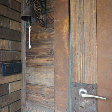 Входная дверь декорирована старым деревом и листовым аутентичным металлом.