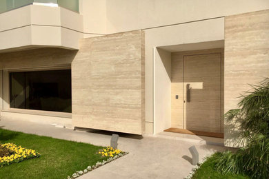 Ejemplo de puerta principal actual con paredes beige, suelo de piedra caliza, puerta simple y suelo beige