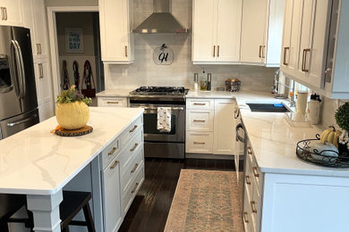 フィラデルフィアにある高級な広いおしゃれなキッチン (シェーカースタイル扉のキャビネット、白いキャビネット、御影石カウンター、白いキッチンパネル、セメントタイルのキッチンパネル、シルバーの調理設備、濃色無垢フローリング、茶色い床、グレーのキッチンカウンター) の写真
