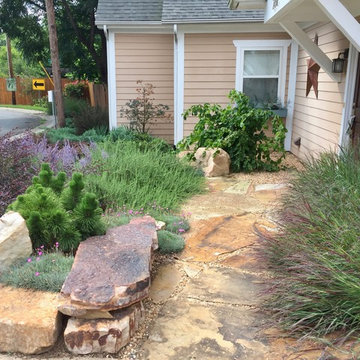 New front sidewalk, softened by textural plantings.
